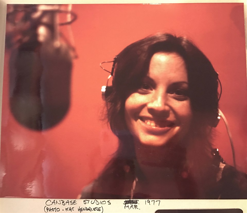 Denise McCann wearing headphones at a studio microphone at Canbase Studios in March 1977